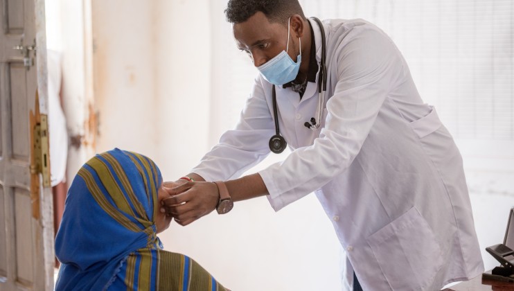 Dr. Hassan Mohamoud Abdi, Team Leader at the Allaybaday Clinic, attends to a patient at the Outpatients' Department