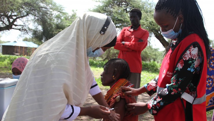 A nurse in Isiolo County, Kenya administers the COVID 19 vaccine to a community member